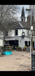 a large white building with a steeple on a street at West Highland Way Rooms ED30002F in Milngavie