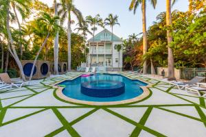 a pool in front of a house with palm trees at Beachfront Villa at Islamorada BY THE GLAMHOMES in Islamorada