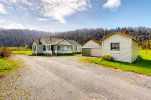 Redwood Farmhouse in the Orick Valley في Orick: طريق ترابي بجانب بيتين على تلة