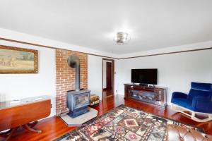 a living room with a fireplace and a tv at Redwood Farmhouse in the Orick Valley in Orick