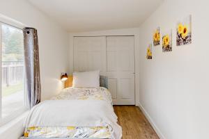 una piccola camera da letto con un letto e una finestra di Cedar Street Cottage a Eureka