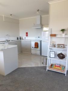 a kitchen with white cabinets and a white appliances at Kiwiana Gem in Reefton