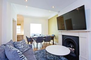 - un salon avec un canapé et une cheminée dans l'établissement Hyde Park Paddington spacious London Home, à Londres
