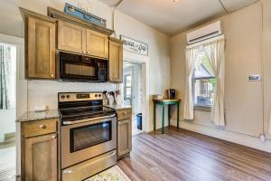 a kitchen with wooden cabinets and a stove top oven at Cave Springs Home about 16 Mi to Razorback Stadium! in Lowell