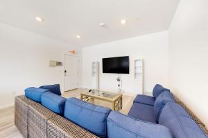 a living room with a blue couch and a tv at 21 Rehoboth Beach House --- 20494 Coastal Highway, Unit #21 in Rehoboth Beach