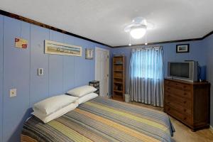 1 dormitorio azul con 1 cama y TV en The Place to be..., en Provincetown