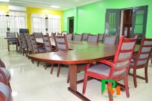 une salle de conférence avec une table et des chaises en bois dans l'établissement RESIDENCES MICKEL, à Yaoundé