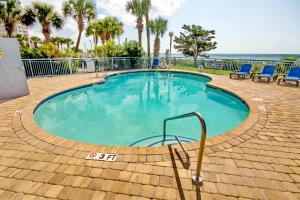 una gran piscina con sillas azules y el océano en Roxanne Towers 303 en Myrtle Beach