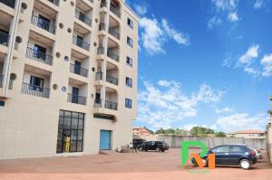 a tall building with a car parked in front of it at RESIDENCES MICKEL in Yaoundé