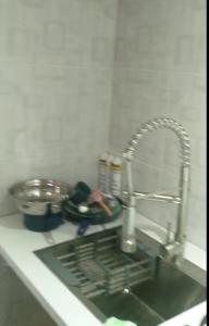 a kitchen counter with a sink next to a sink at Small cosy house (simple but complete) in Asgad