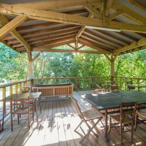 una terraza de madera con mesa y sillas. en Le Tipi Glamour au bord de la rivière en Mios