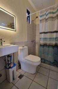 a bathroom with a toilet and a sink and a shower at CityLofts Plainview in Mandaluyong corner unit in Manila