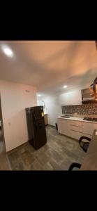 - une cuisine avec un réfrigérateur noir dans la chambre dans l'établissement Apartamento amplio y confortable, à Medellín