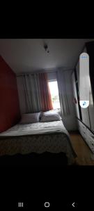 um pequeno quarto com uma cama e uma janela em Meu cantinho em Tiradentes