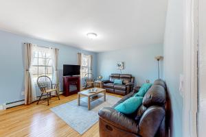 Blue Jay في Castine: غرفة معيشة مع أريكة جلدية وطاولة