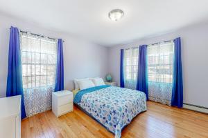 a bedroom with blue curtains and a bed in a room at Blue Jay in Castine