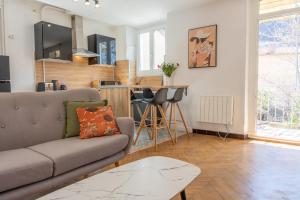 salon z kanapą i stołem w obiekcie Appartement T3 63m2 - L'Atypique et son Jardin de 350m2 au cœur de Digne w mieście Digne-les-Bains