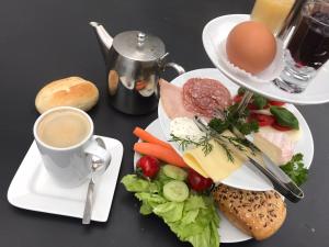 - une table avec deux assiettes de nourriture et une tasse de café dans l'établissement Hotel Gleis 3viertel Jena, à Iéna