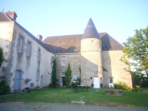 una casa antigua con un gran edificio con una torreta en Manoir de la Chapelle en Condé-sur-Sarthe