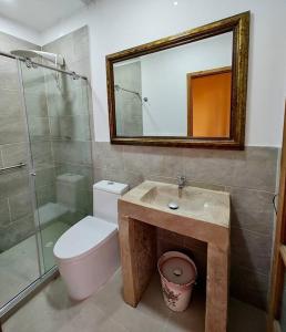 uma casa de banho com um WC, um chuveiro e um espelho. em Casa Finca El Mirador frente a la laguna de Fúquene em Fúquene
