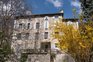 un antiguo edificio de piedra con árboles delante de él en Appartement T3 63m2 - L'Atypique et son Jardin de 350m2 au cœur de Digne en Digne-les-Bains