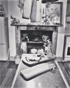 a black and white photo of a kitchen with a fireplace at Barossa Valley’s Captain Rodda’s Cottage in Angaston