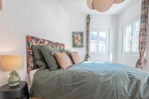 a bedroom with a bed with a blue comforter at Appartement T3 63m2 - L'Atypique et son Jardin de 350m2 au cœur de Digne in Digne-les-Bains