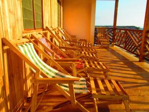 una fila de sillas sentadas en un balcón en Sunset Bed and Breakfast, en San Jacinto