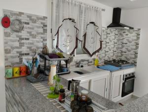 uma cozinha com um lavatório e uma bancada em magnifique maison, bien équipé em Kelibia