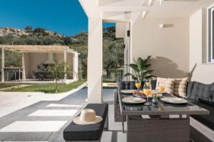 a table and chairs on a patio with a view at Melissia Luxury Villa in Zakynthos