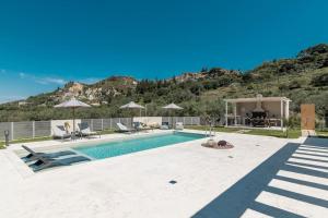 a house with a swimming pool in front of a mountain at Melissia Luxury Villa in Zakynthos Town