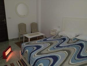 um quarto com uma cama grande, uma mesa e cadeiras em magnifique maison, bien équipé em Kelibia