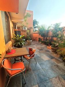 un patio con tavolo, sedie e piante di El Ultimo Maya ad Akumal