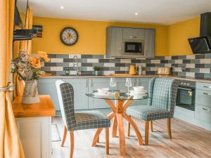 a kitchen with a table and chairs and a counter at Swallow Lodge - Uk42540 in Winforton