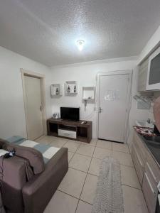 a living room with a couch and a television at Apartamento Aconchego in Bento Gonçalves