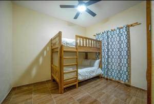 VillaLunaCaridad في جاراباكو: غرفة مع سرير بطابقين ومروحة سقف