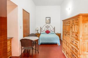 a bedroom with a bed and a table and chairs at Hotel Posada del Centro in Oaxaca City