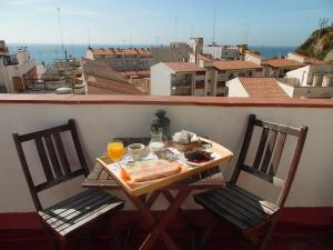a table with food and two chairs on a balcony at Hostal La Lluna in Arenys de Mar