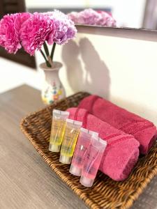 a tray with pink towels and a vase with flowers at Homestay Bayou Lagoon Ayer Keroh Melaka by AlliEyka in Melaka