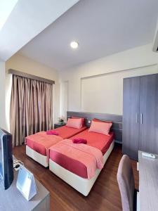 a bedroom with a large bed with red sheets at Homestay Bayou Lagoon Ayer Keroh Melaka by AlliEyka in Melaka
