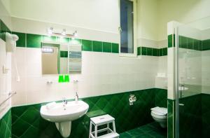 baño verde y blanco con lavabo y aseo en Budapest Rooms Bed and Breakfast, en Budapest