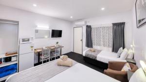 um pequeno quarto com uma cama e uma cozinha em Parkes Federation Motel em Parkes