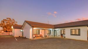帕克斯Parkes Federation Motel的一栋前面有车道的房子