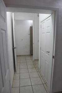 pasillo con puertas blancas y suelo de baldosa en Hostal Purísima, en San Francisco del Rincón