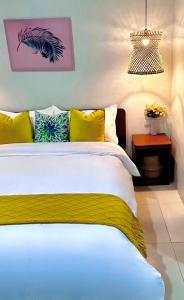 sypialnia z dużym łóżkiem z żółtymi i niebieskimi poduszkami w obiekcie HOTEL Pinc w mieście General Santos