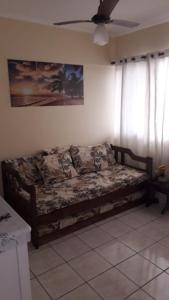 a couch in a living room with a ceiling fan at Lindo apartamento em frente a praia in Praia Grande