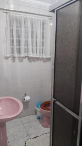 a bathroom with a pink toilet and a sink at Lindo apartamento em frente a praia in Praia Grande
