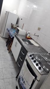 a kitchen with a stove and a sink at Lindo apartamento em frente a praia in Praia Grande