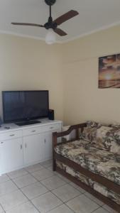 a bedroom with a bed and a flat screen tv at Lindo apartamento em frente a praia in Praia Grande