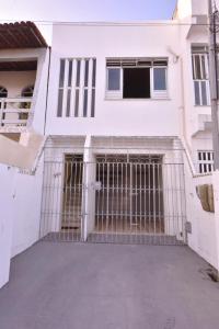 ein weißes Haus mit einem Tor davor in der Unterkunft Casa no Centro, Home Office com ar condicionado in Aracaju